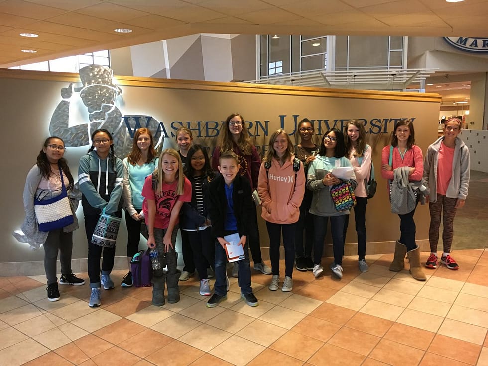 The EMS book club posing in front of the Washburn University logo!